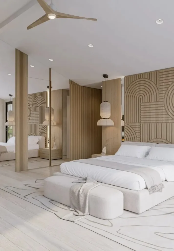 Modern bedroom with a large white bed, wooden wall panels, and ceiling fan.