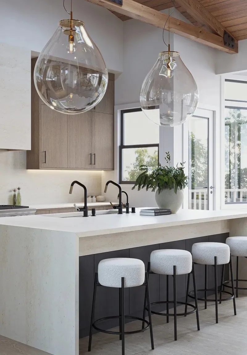 Modern kitchen island with clear glass pendant lights and white bar stools.